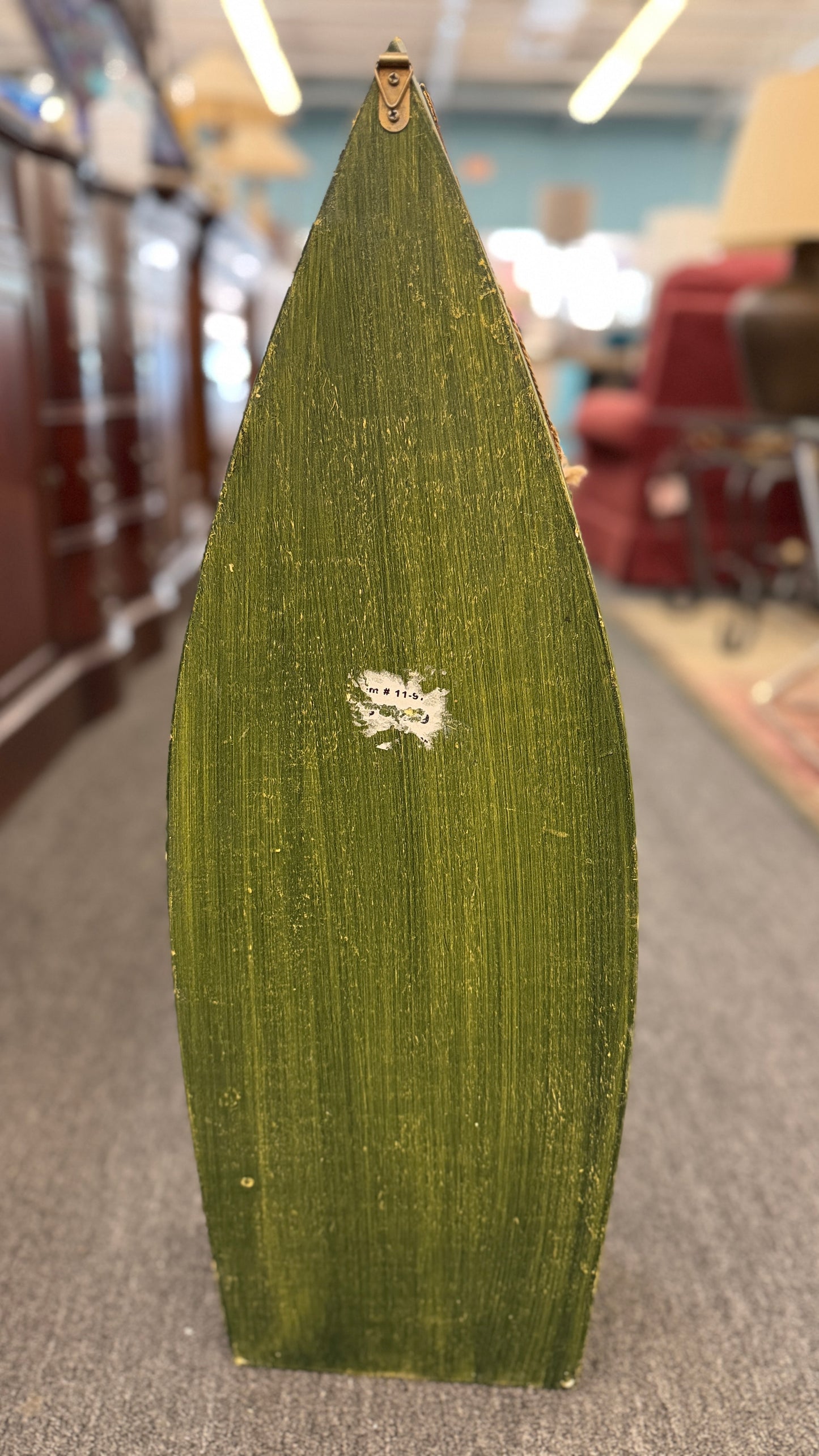 Green leaf with a logo on a blurred indoor background