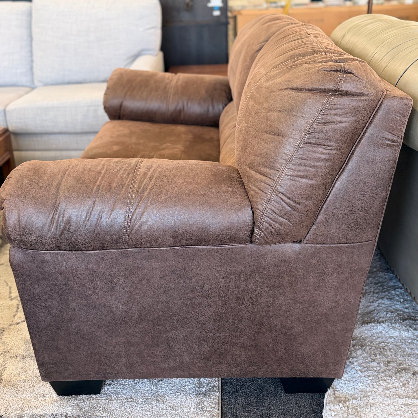 Brown leather sectional sofa in a showroom setting