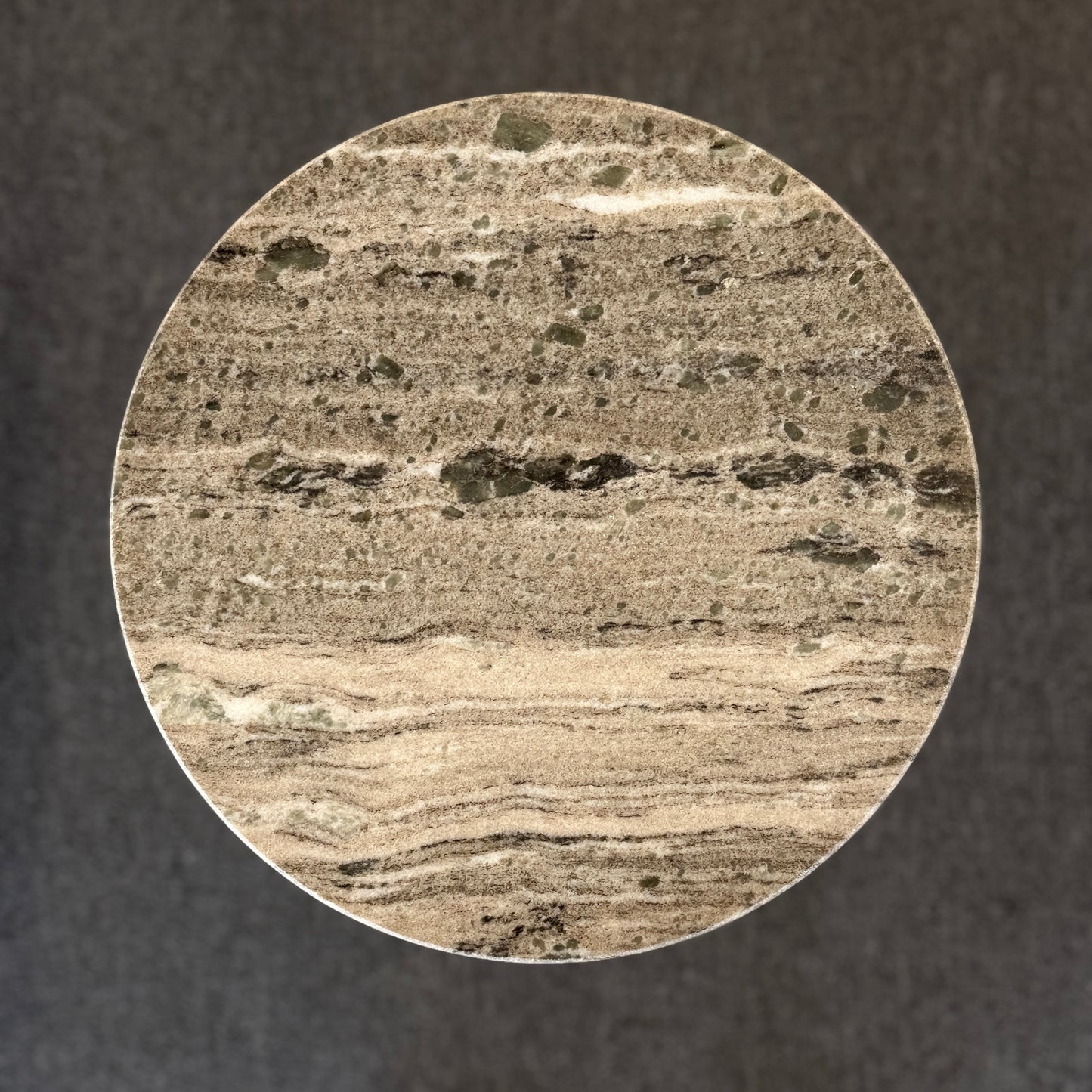Close-up of a circular stone with layered texture on a dark background