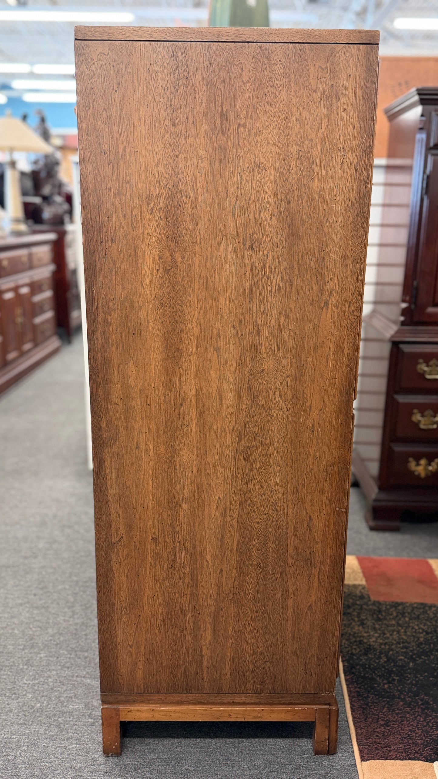A vintage wooden armoire storage cabinet featuring a symmetric four-panel door facade with recessed molding and antiqued brass ring pull handles.