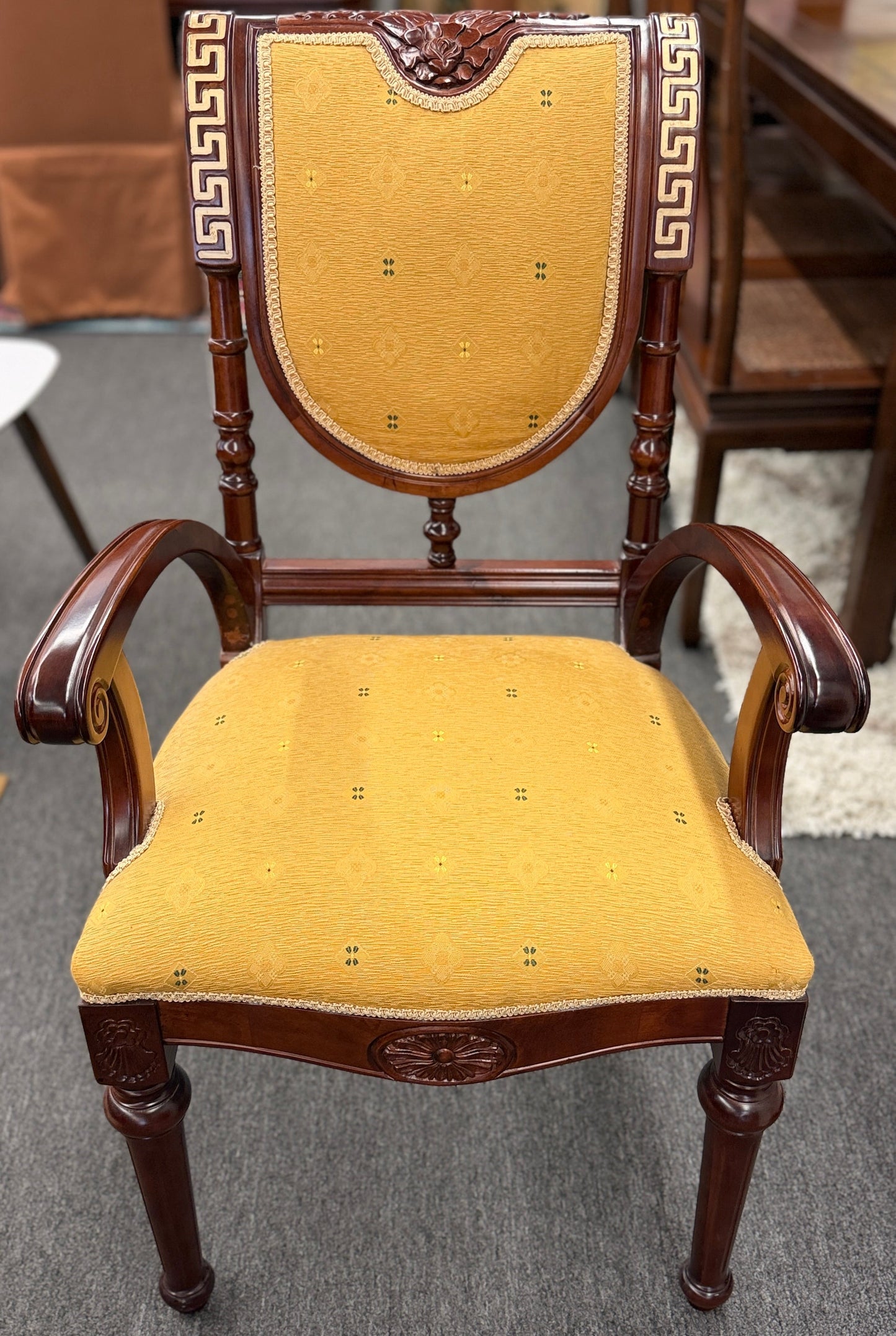 A 5-piece traditional game table set featuring a square wood table with a green felt surface and cup holders, surrounded by four rolling armchairs in yellow patterned upholstery with a Greek key trim.