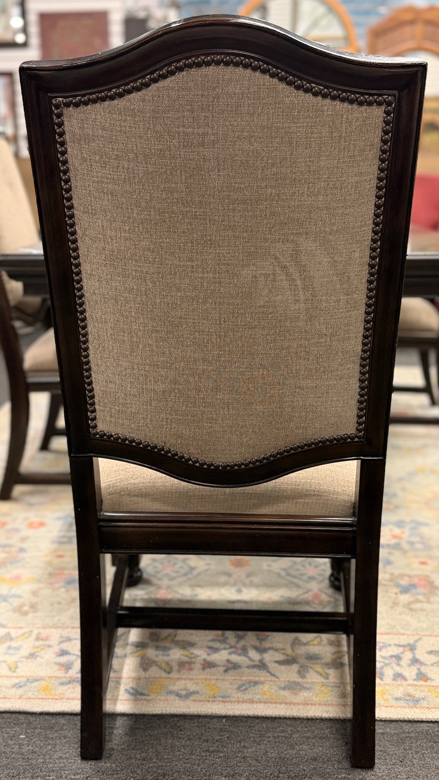A traditional 7-piece dining set featuring a large rectangular wooden table, two high-back host armchairs, and four matching side chairs with fabric upholstery.