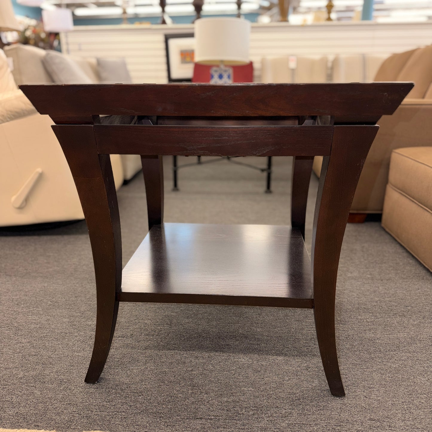Square dark wood end table featuring a glass top with an intricate woven metal inlay and a lower display shelf.