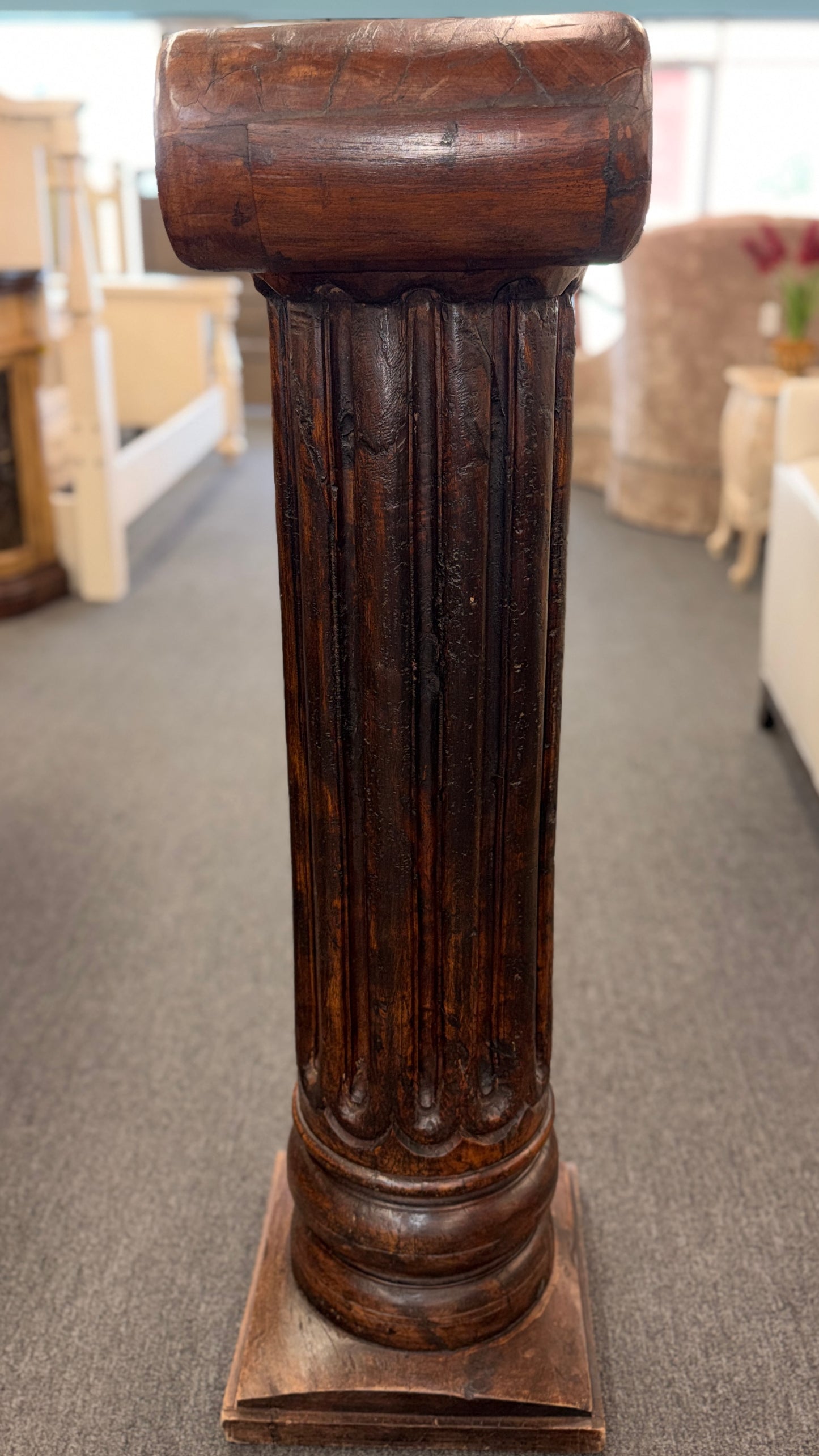 A classical wooden architectural pedestal featuring a carved Ionic scroll capital with floral motifs, a fluted shaft, and a square plinth base in excellent condition.