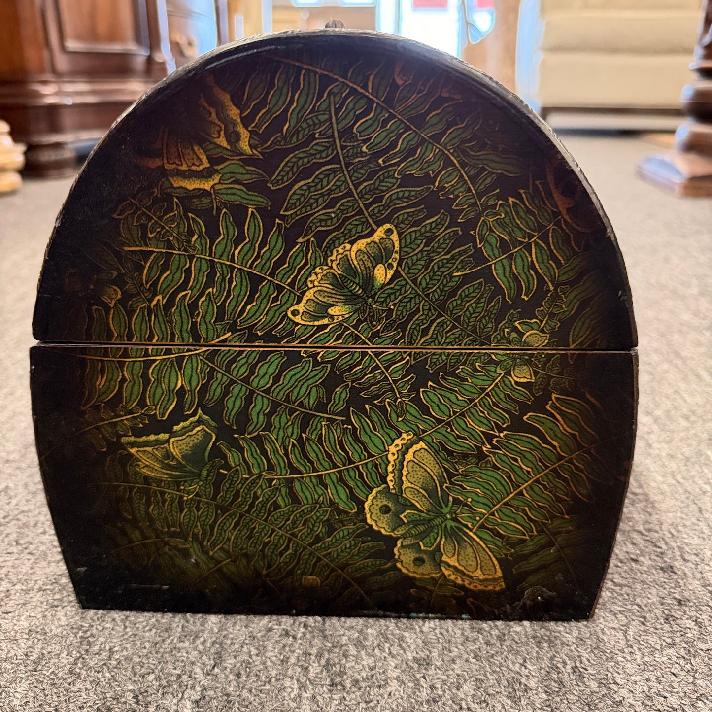 A small domed-top wooden treasure chest featuring green fern patterns, gold butterfly motifs, a metal swing clasp, and top handle in good condition.