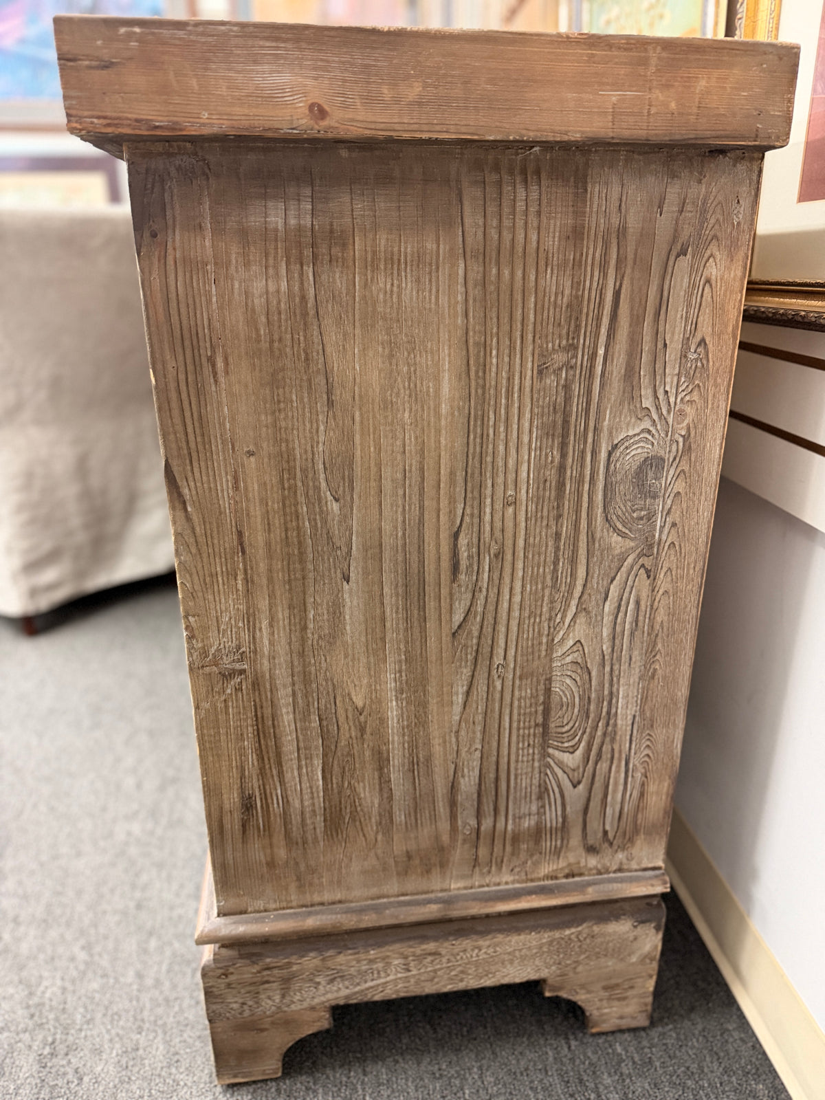 A large rustic Mediterranean-style credenza sideboard crafted from weathered wood featuring four relief-carved cabinet doors and three center drawers with dark ring pulls in good condition.