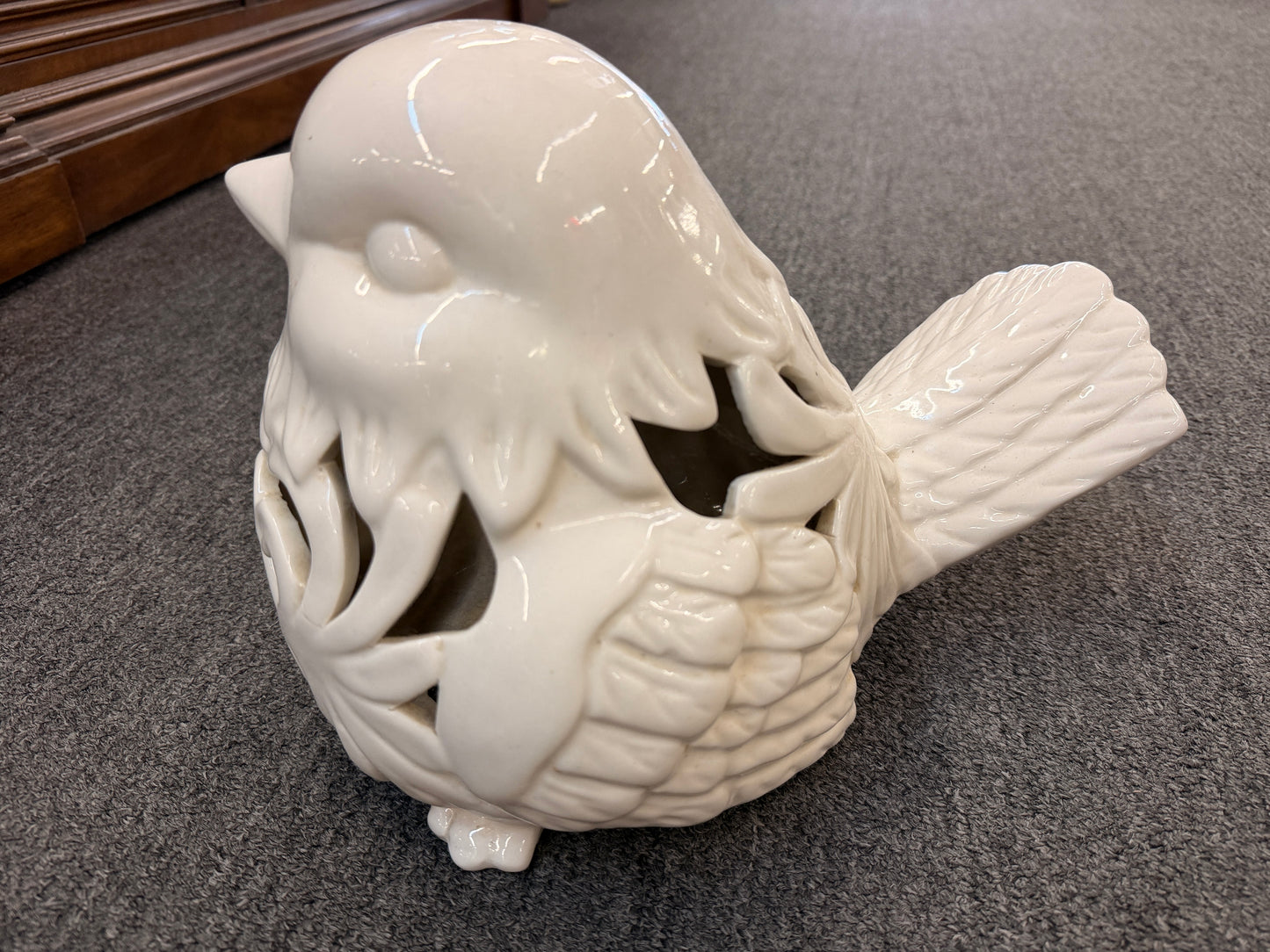 A cream glazed ceramic bird figurine featuring decorative openwork cutout hearts designed to hold a tealight or small candle in excellent condition.