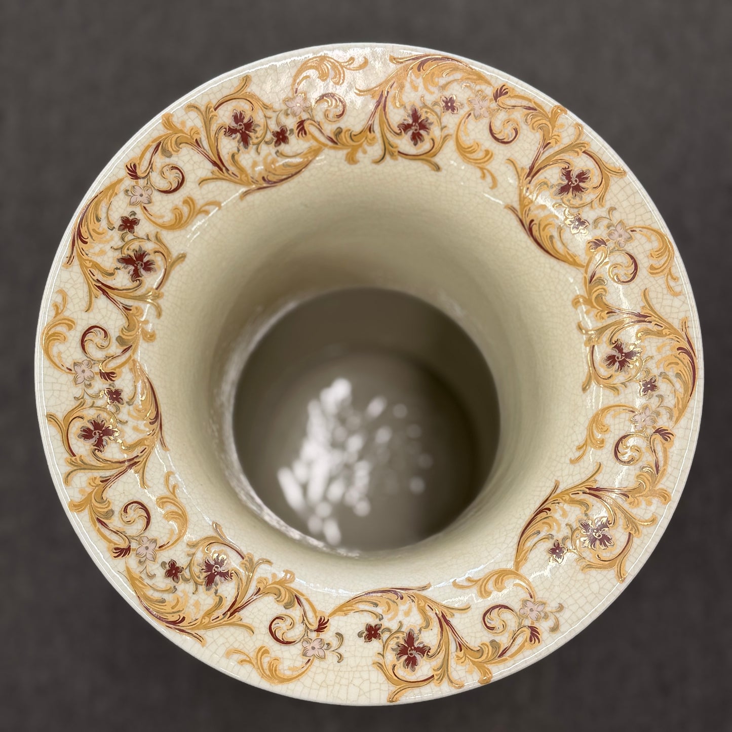 Traditional gold and brown filigree ceramic floor vase with intricate decorative patterns on a curved wood stand at 2nd Debut Houston consignment showroom