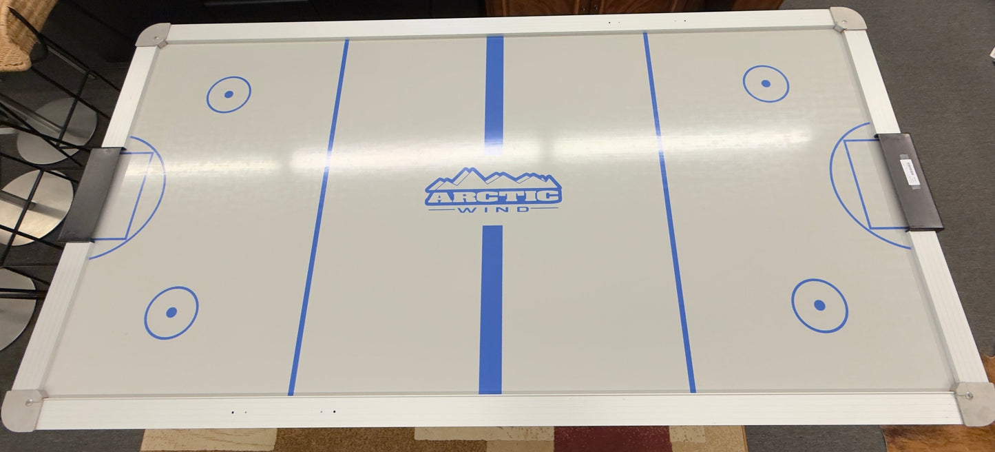 Full-size air hockey table with a white playing surface, blue boundary lines, sturdy black frame, and durable legs for home game room entertainment.