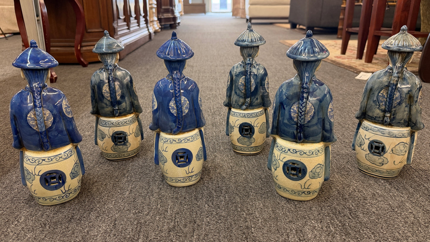 A set of six hand-painted blue and white porcelain figurines depicting seated Qing Dynasty scholars in traditional robes and mandarin hats in excellent condition.