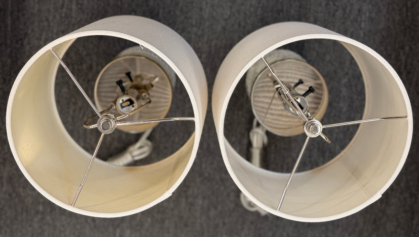 A pair of identical table lamps featuring textured white cylindrical ceramic bases with a geometric diamond pattern, white drum shades, and silver-toned hardware.