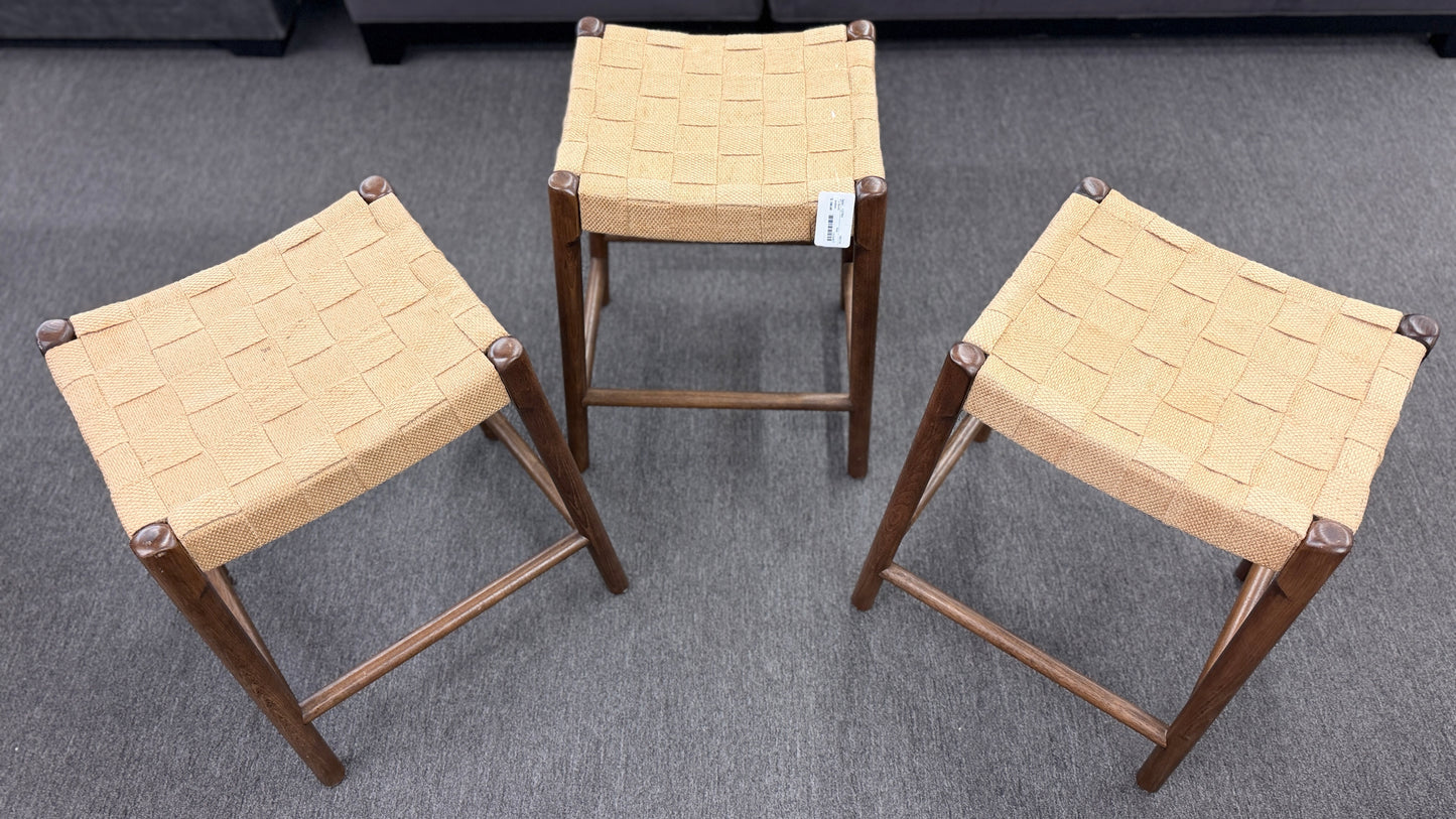 A set of three wooden backless barstools featuring woven natural-fiber seats in good condition.