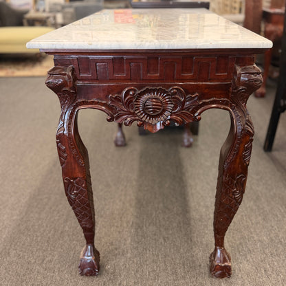 A Chippendale-style marble-top console table featuring an intricately carved mahogany apron, Greek key border, and cabriole legs with ball-and-claw feet in good condition.
