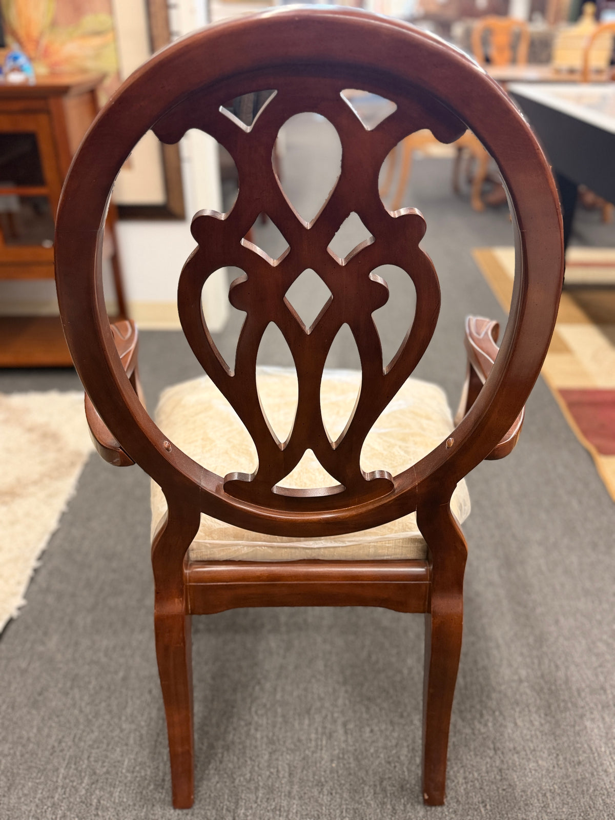 A traditional dark wood dining set including a rectangular table and four chairs with ornate backrests and light upholstered seats in excellent condition.