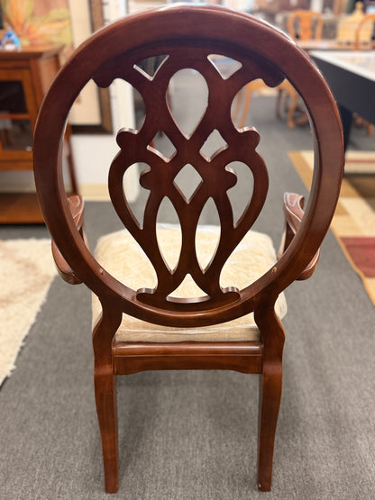 A traditional dark wood dining set including a rectangular table and four chairs with ornate backrests and light upholstered seats in excellent condition.