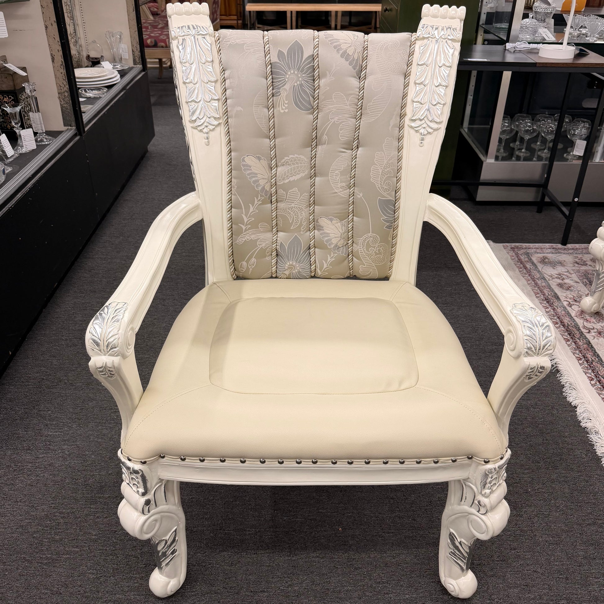 Decorative armchair with intricate carvings in a showroom setting