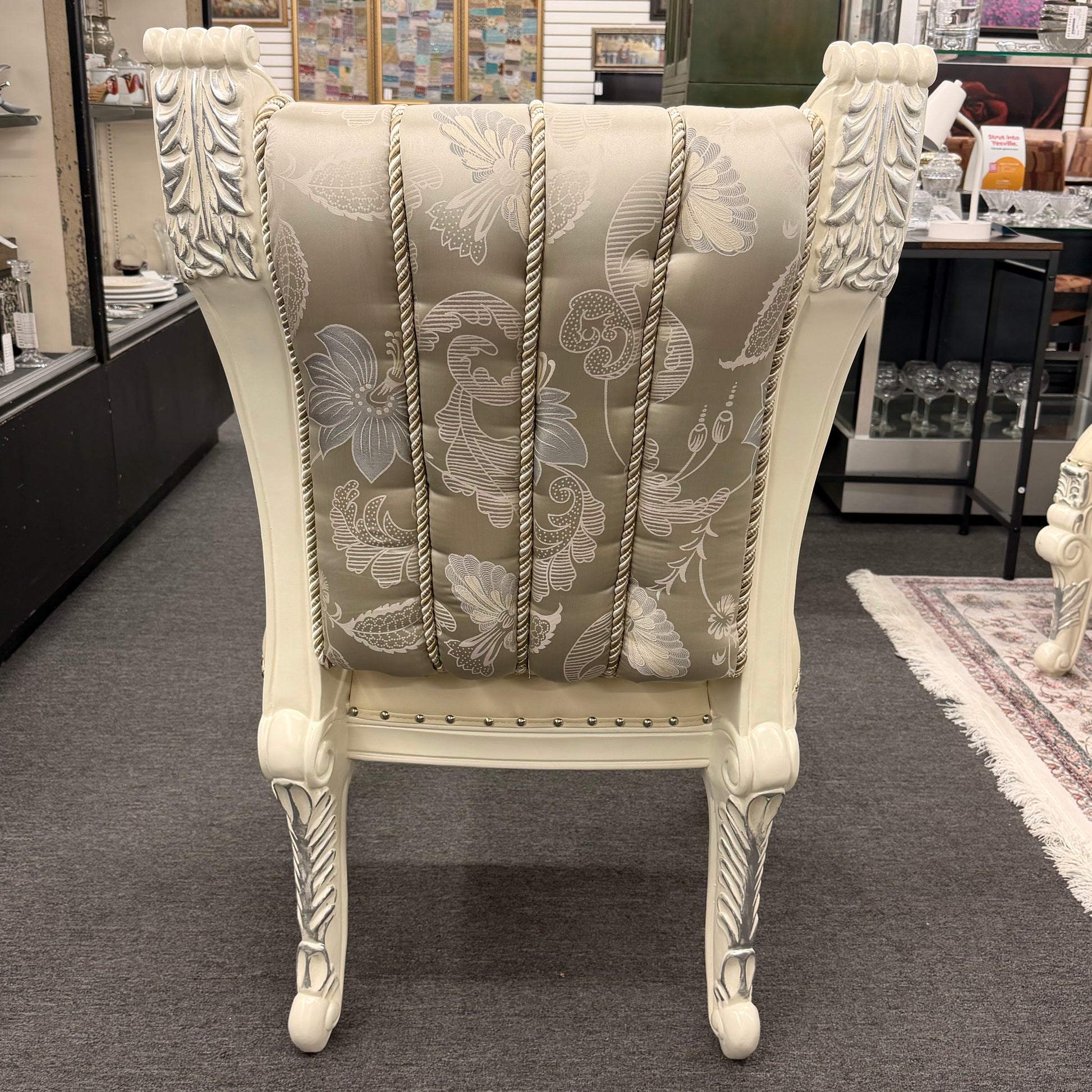 Decorative chair with floral pattern and ornate design in a store setting