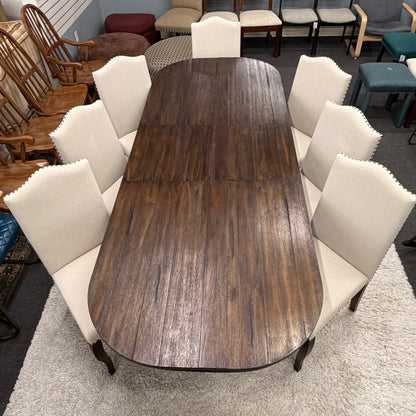Wooden dining table with white chairs in a showroom setting
