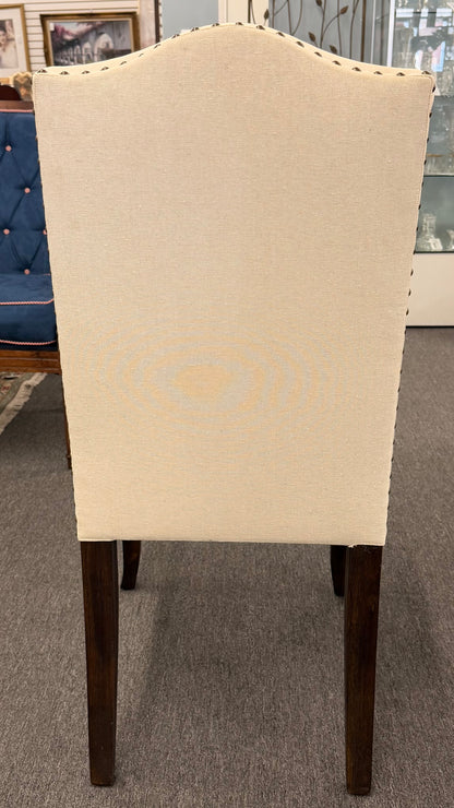 Beige upholstered chair with wooden legs on a gray carpet