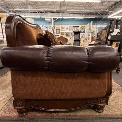 Brown leather sofa in a store setting with various items in the background