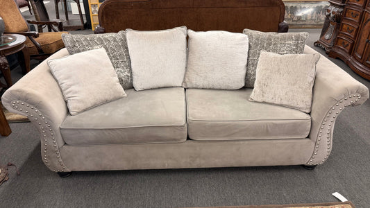 Gray sofa with decorative pillows in a furniture store setting
