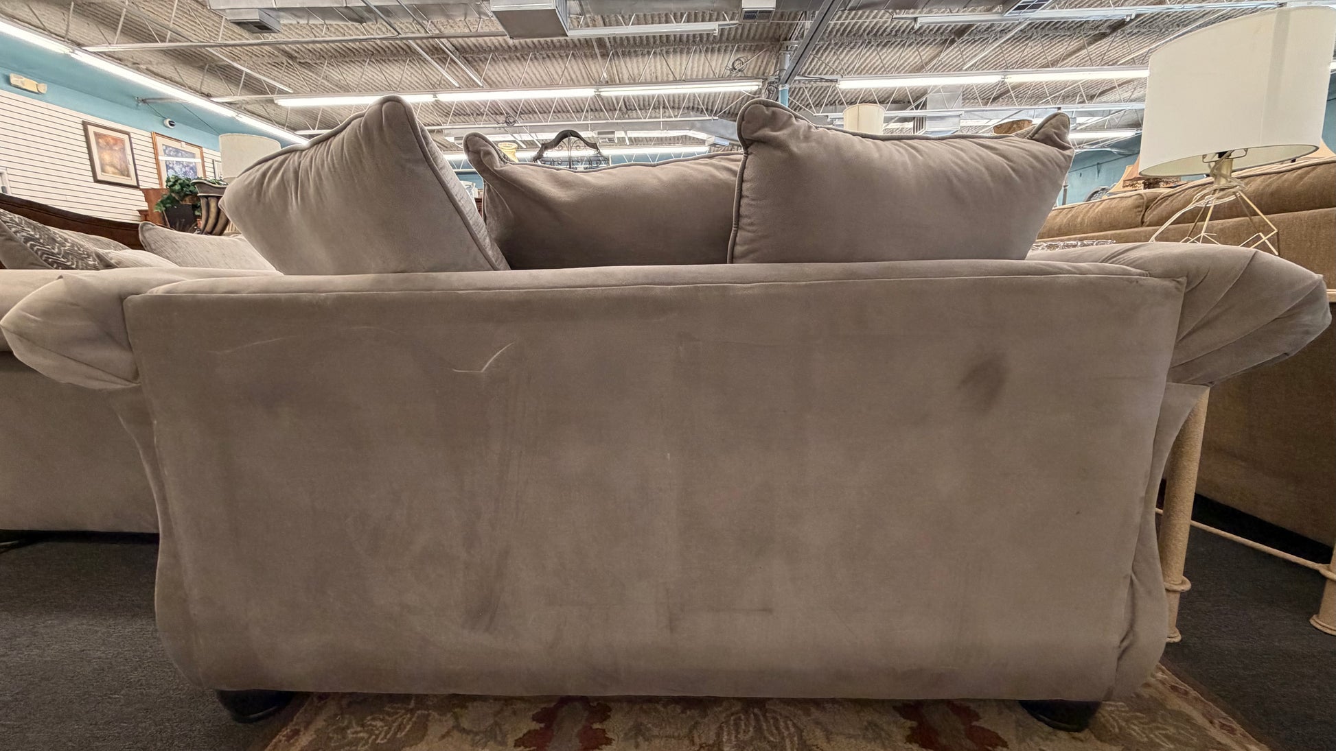 Gray sofa with cushions in a store setting