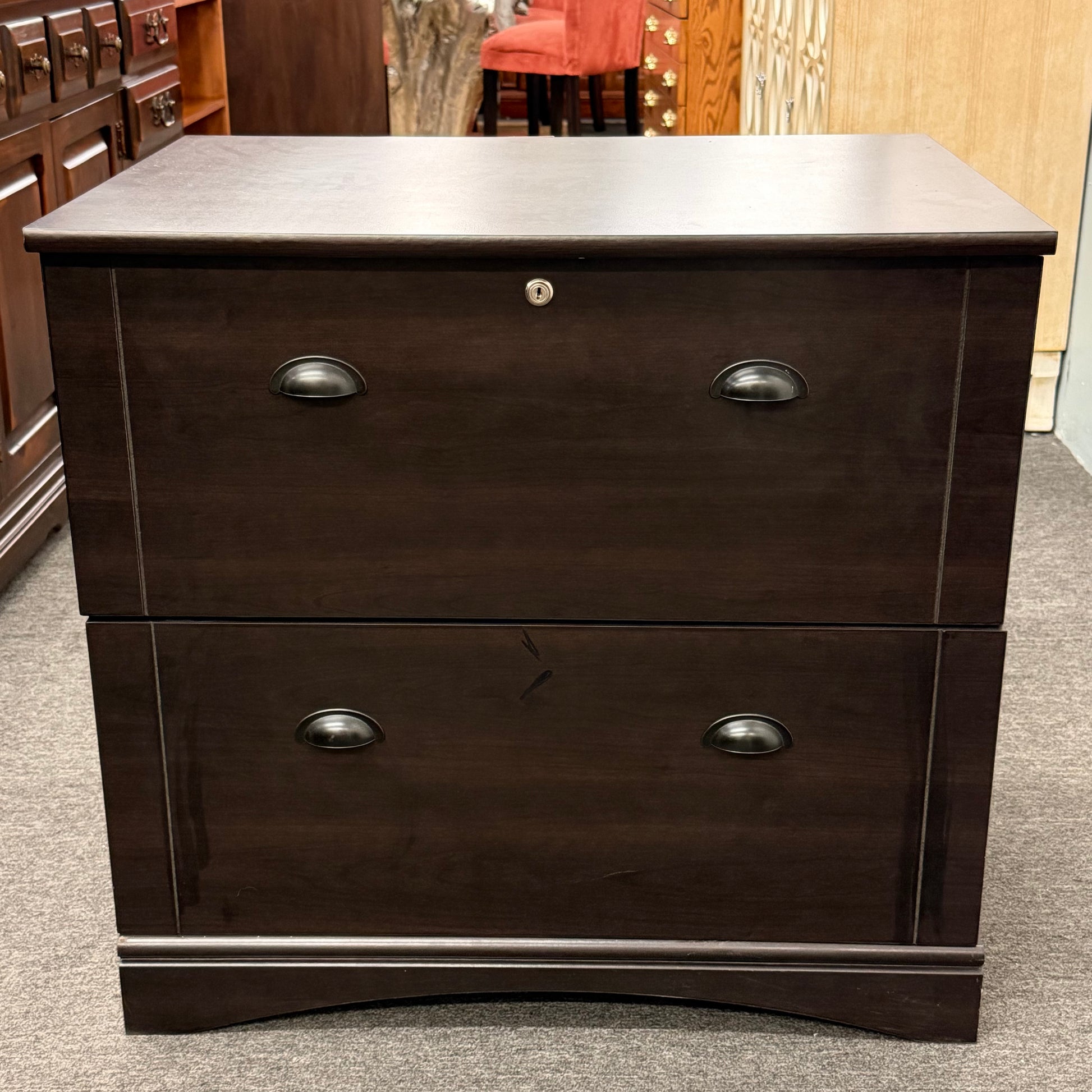 Dark wood dresser with two drawers on a carpeted floor.