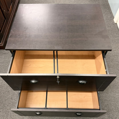Open drawer of a piece of furniture with a dark surface