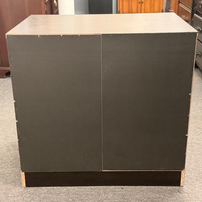 Dark gray cabinet with two doors on a gray floor.