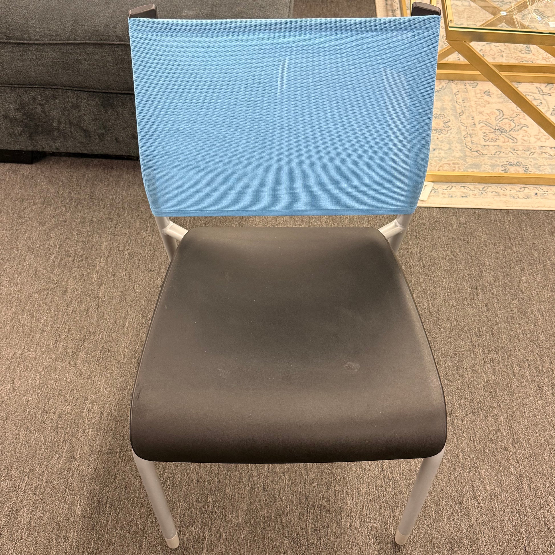 Chair with blue backrest and gray seat on a carpeted floor.