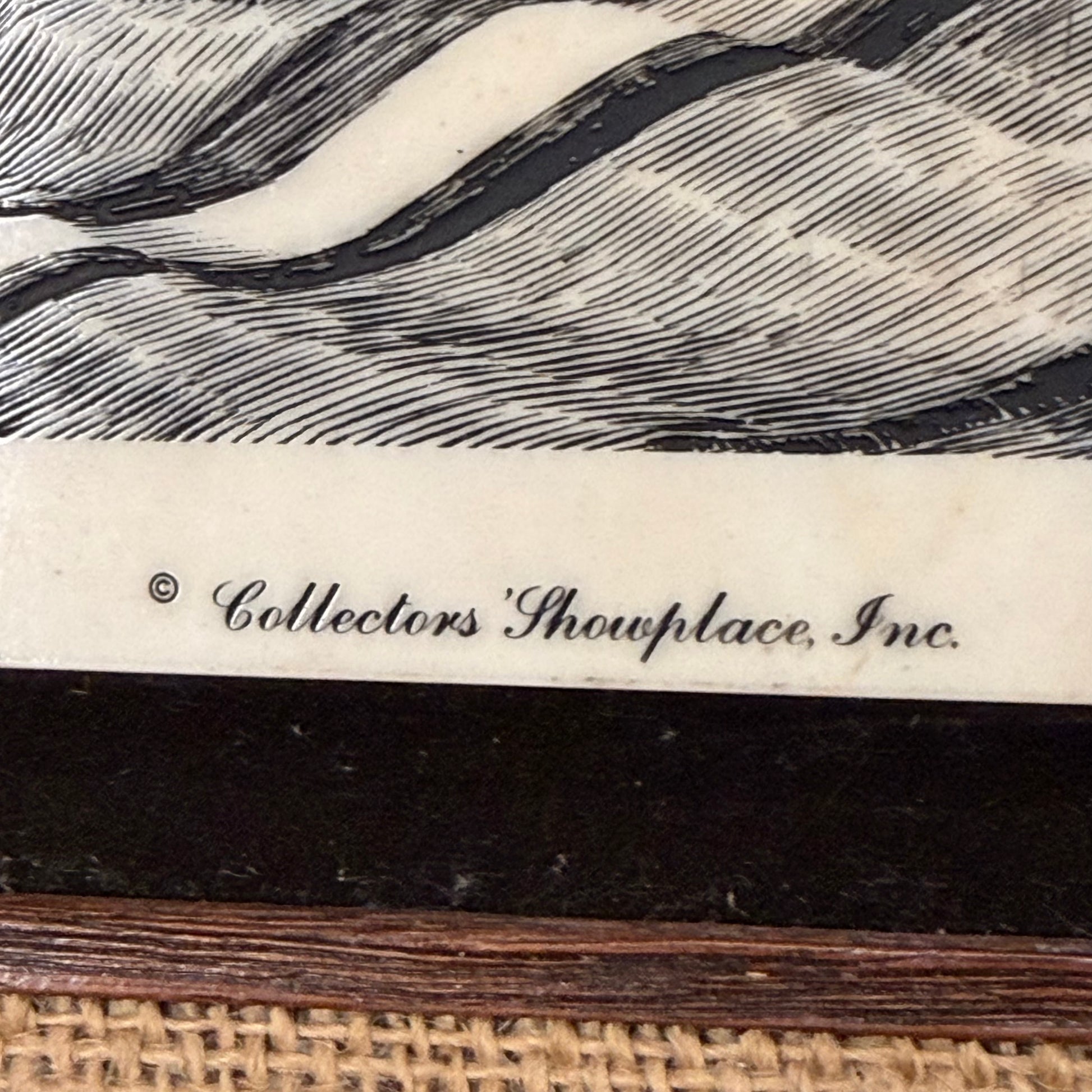 Close-up of a decorative item with wicker base, textured surface, and 'Collectors' Showplace, Inc.' branding.