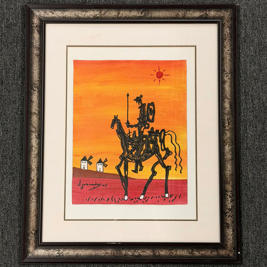 Framed artwork of Don Quixote on horseback against an orange sunset with windmills.
