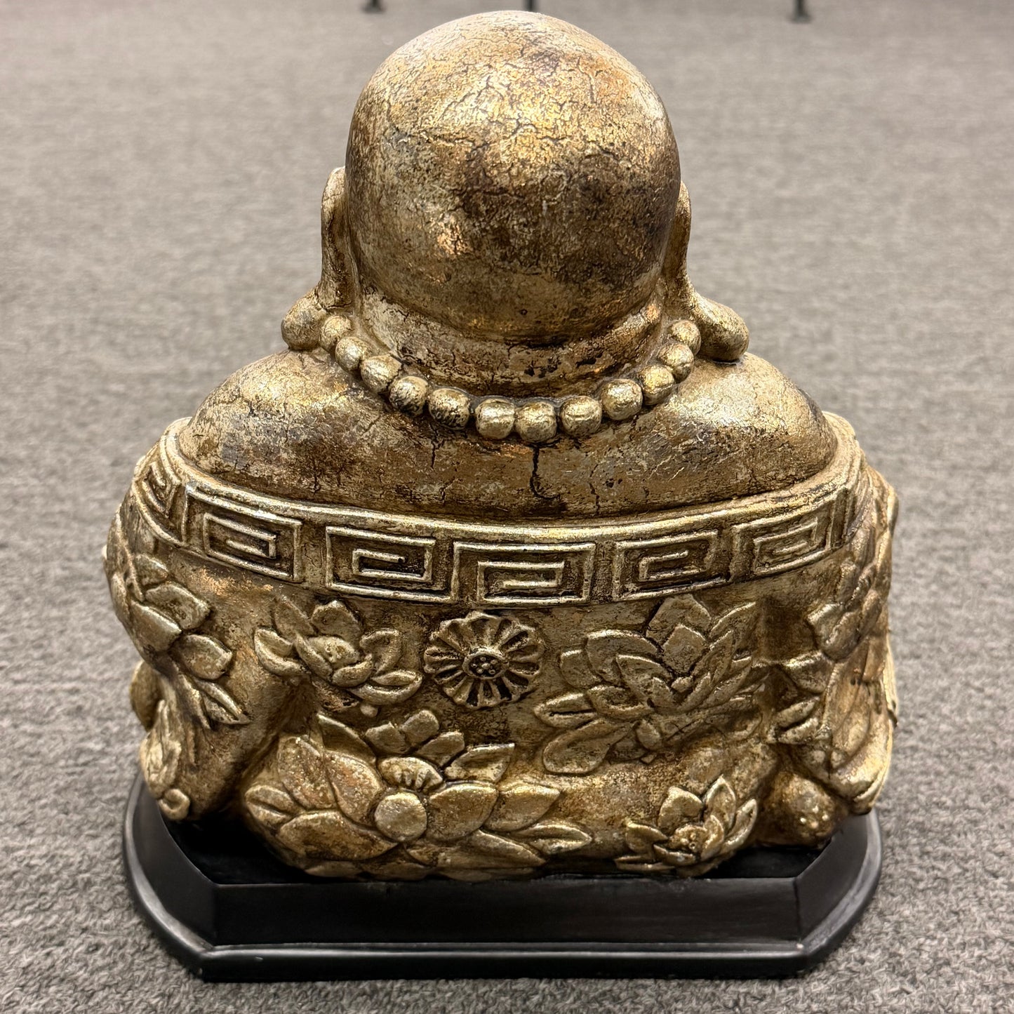 Bronze Buddha statue on a gray carpet