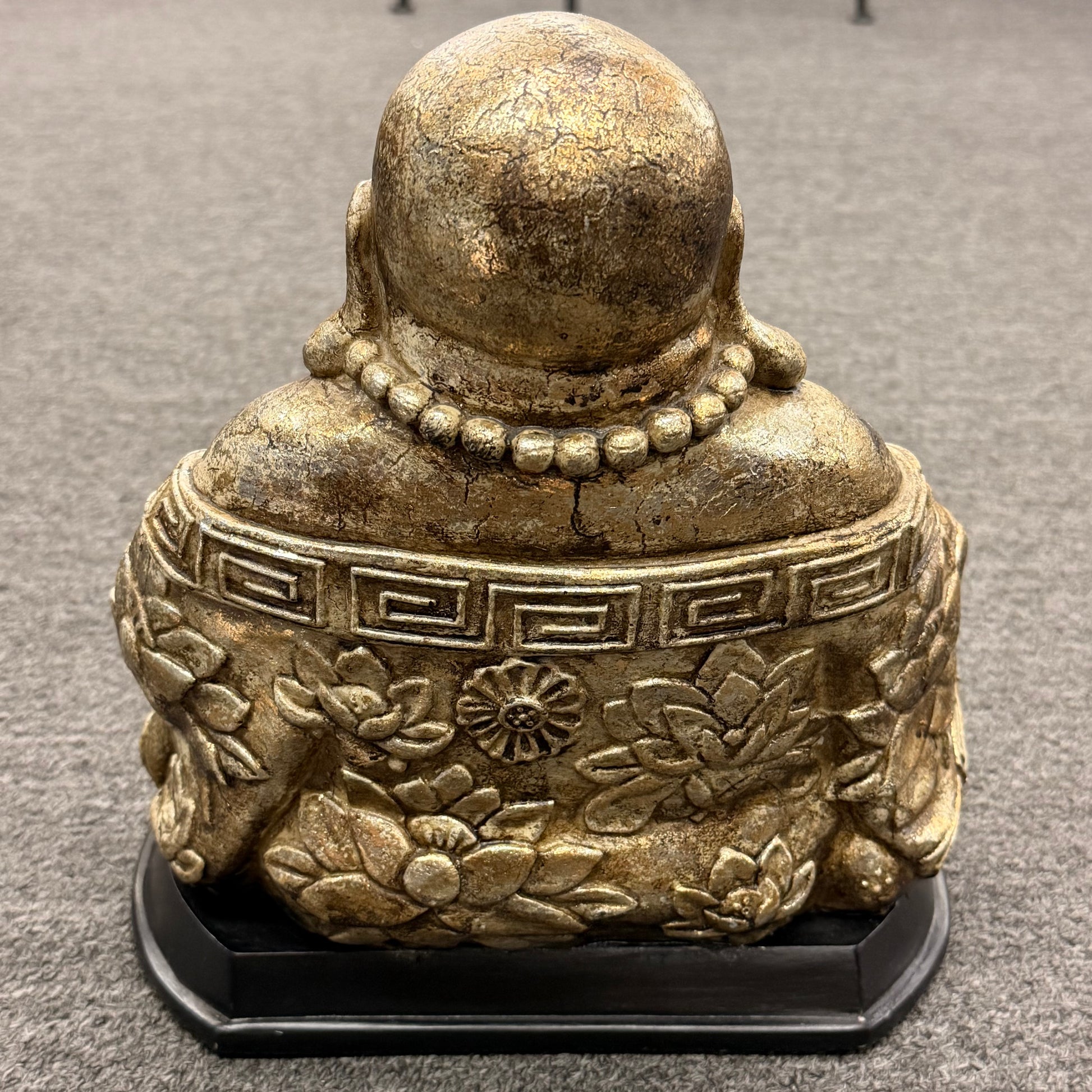 Bronze Buddha statue on a gray carpet
