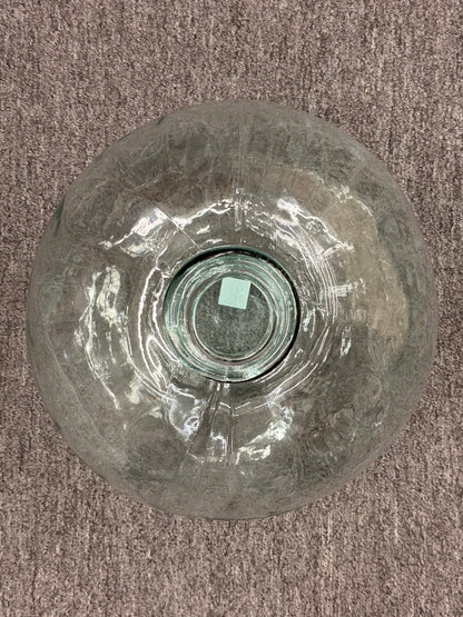 Glass vase with a large crack on a brown carpet