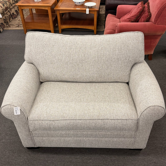 Gray armchair in a room with furniture and decor