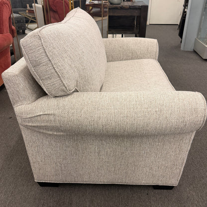 Gray armchair with a pillow in a showroom setting