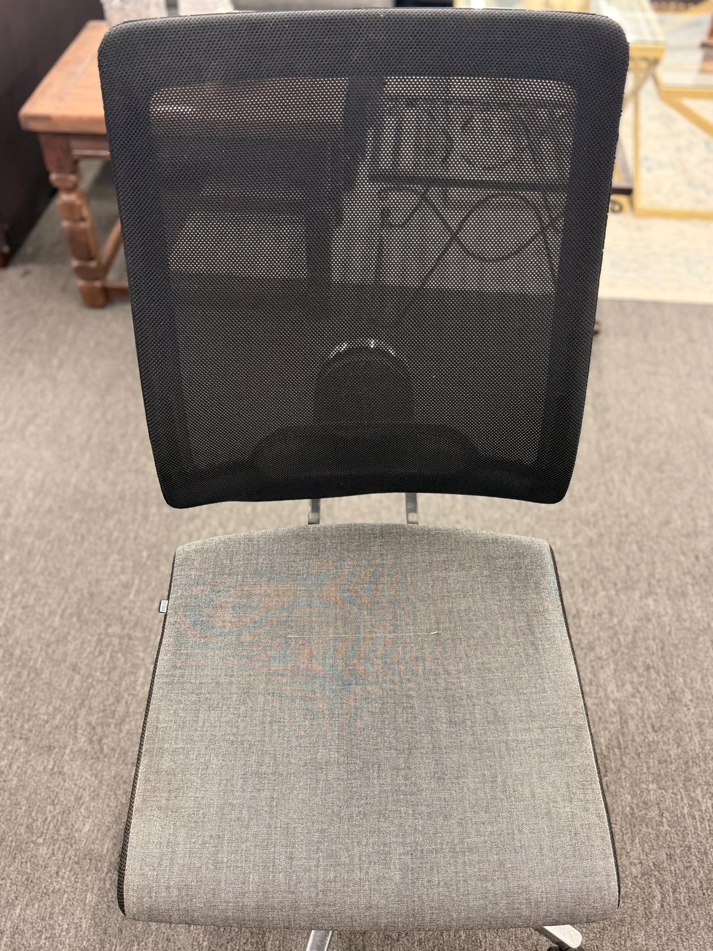 Gray office chair with mesh backrest on a carpeted floor