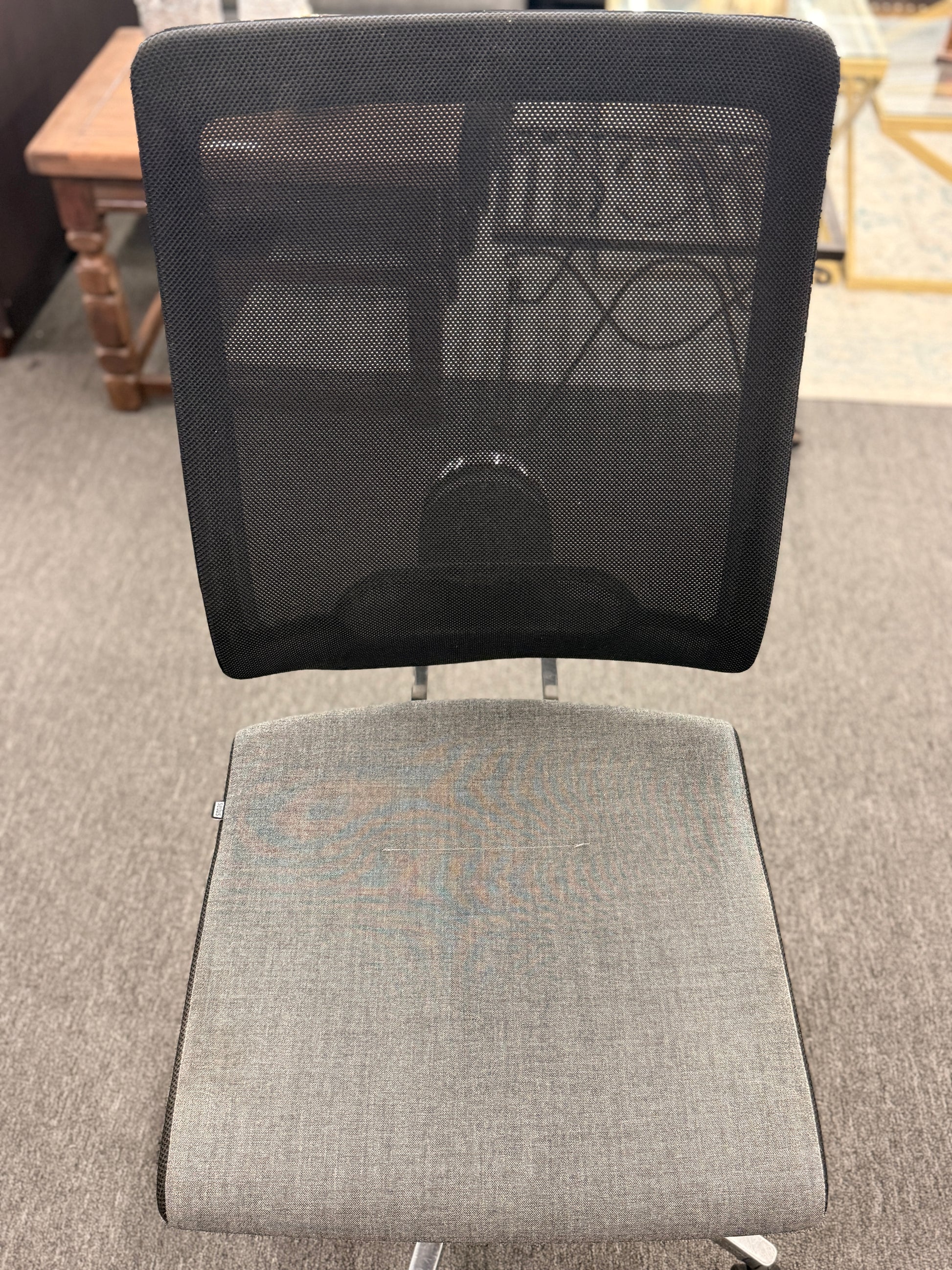 Gray office chair with mesh backrest on a carpeted floor