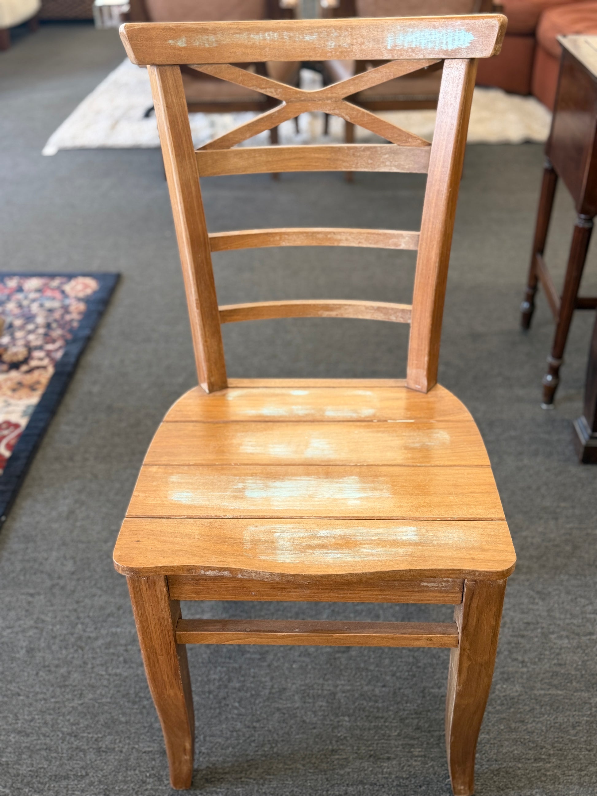 Wooden chair with slatted design on a carpeted floor