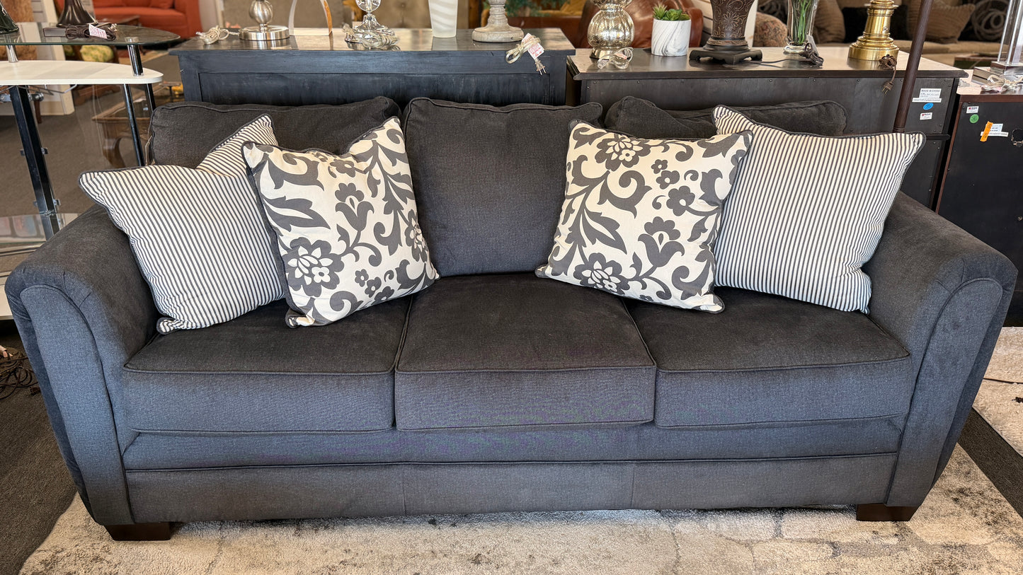 Gray sofa with patterned cushions in a room setting