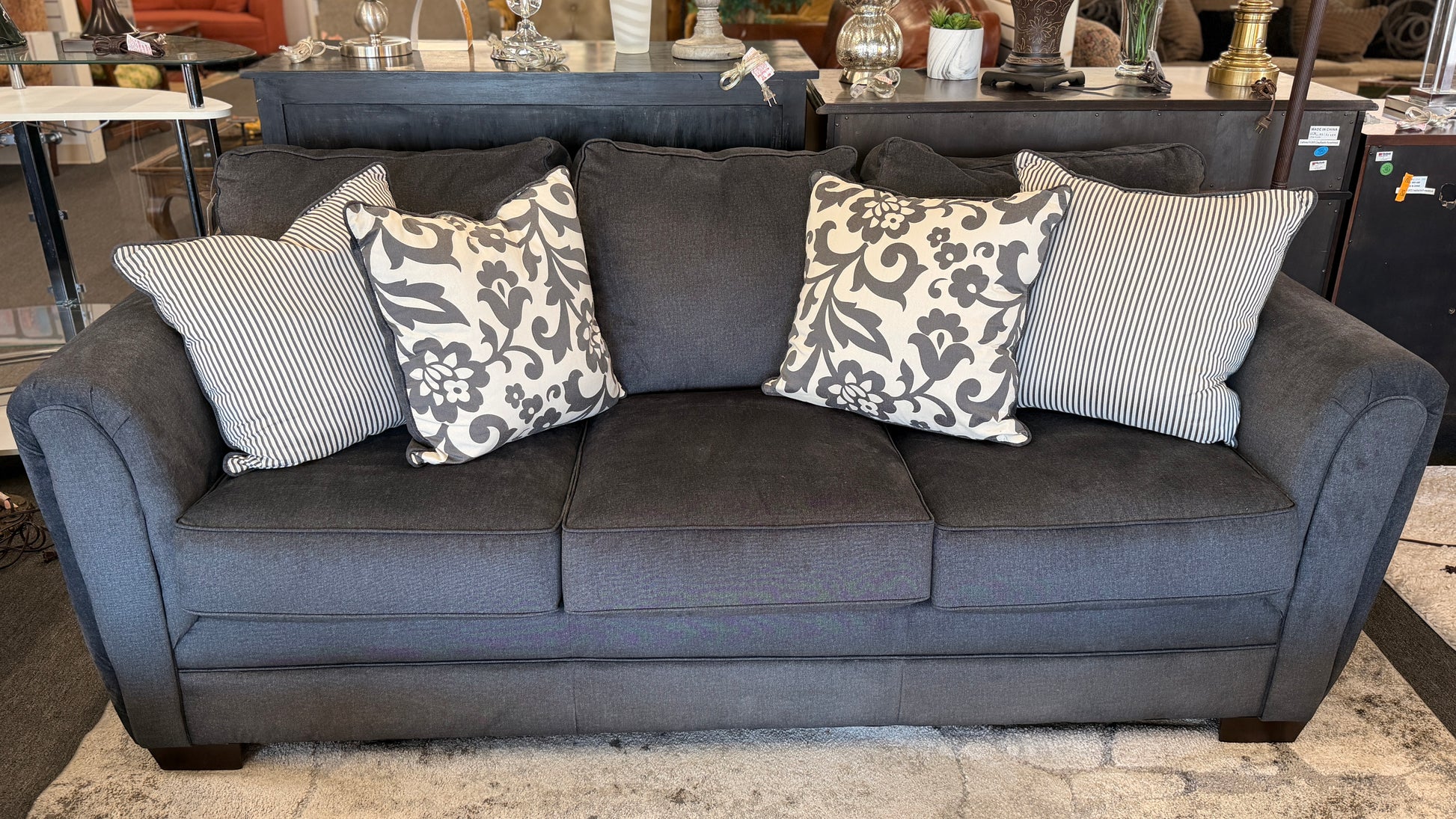 Gray sofa with patterned cushions in a room setting