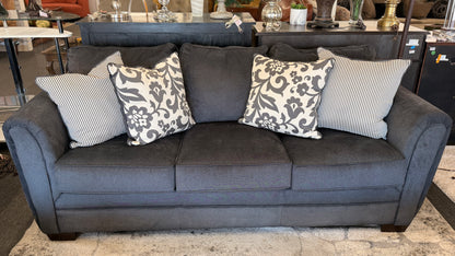 Gray sofa with patterned cushions in a room setting
