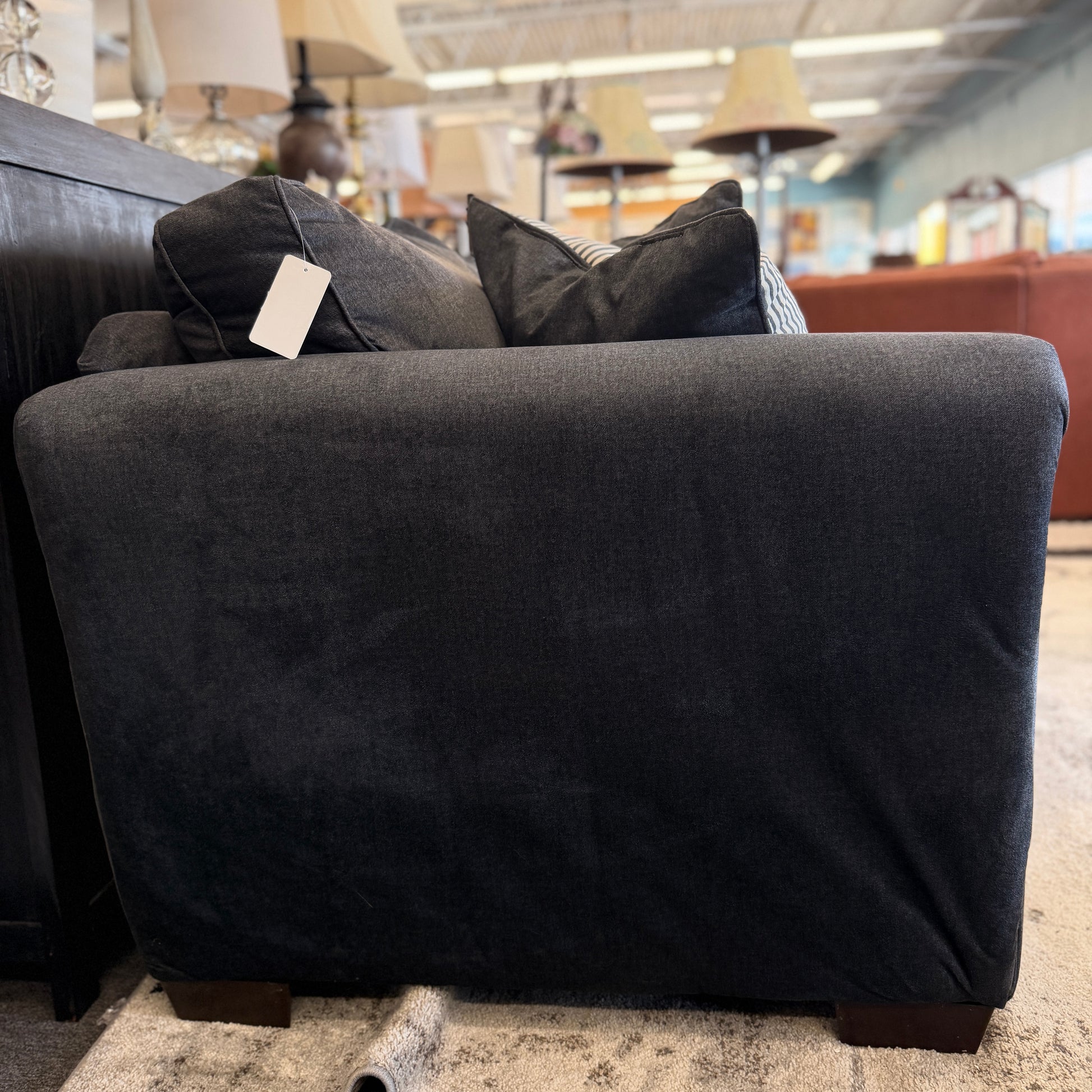 Gray armchair with cushions in a store setting
