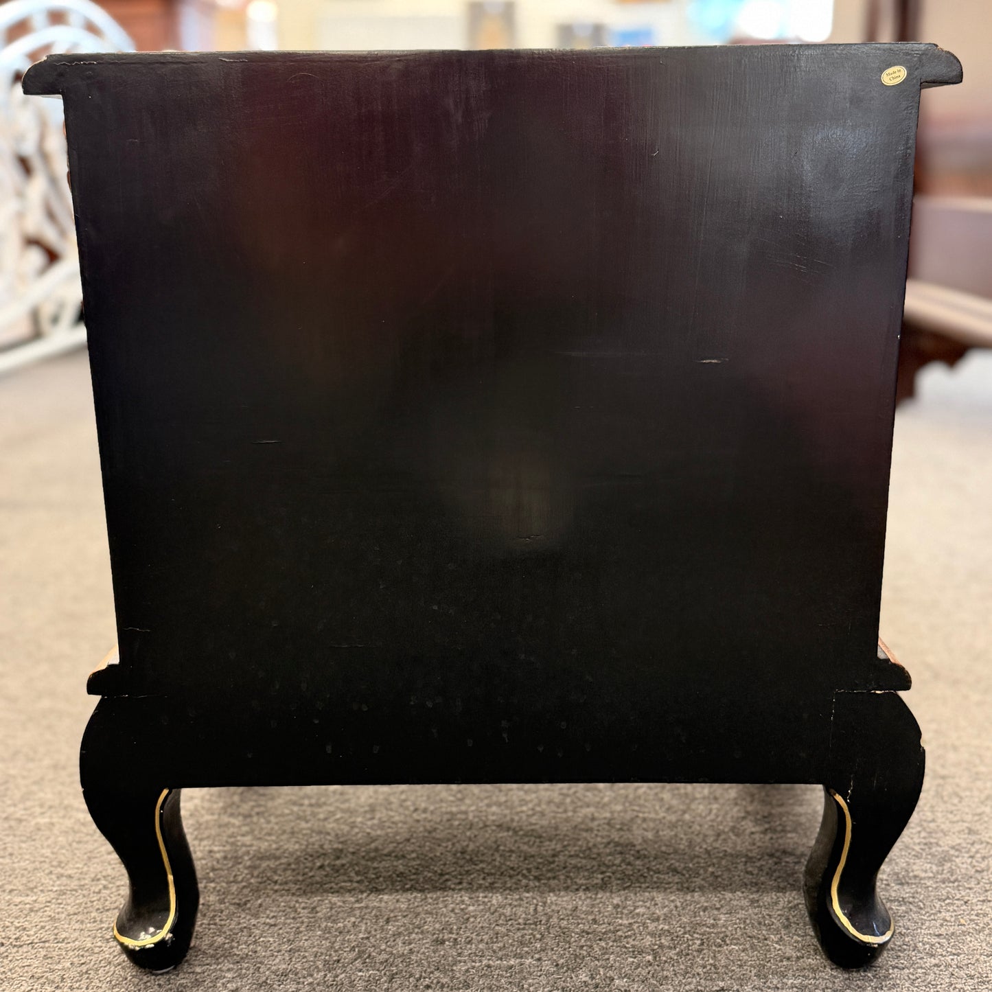 Black fireplace screen with decorative legs on a carpeted floor