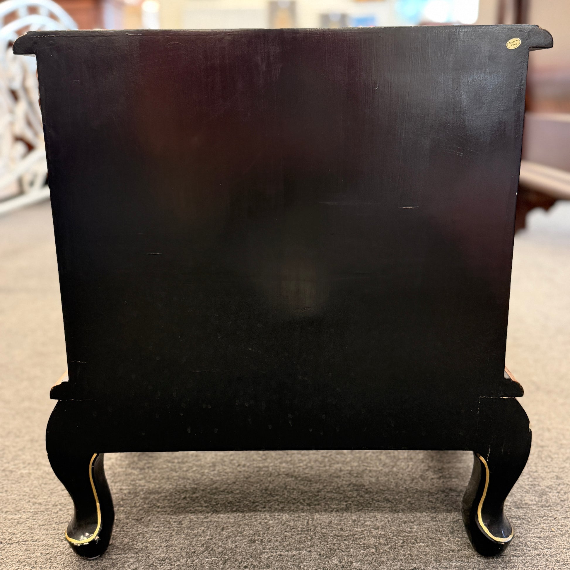 Black fireplace screen with decorative legs on a carpeted floor