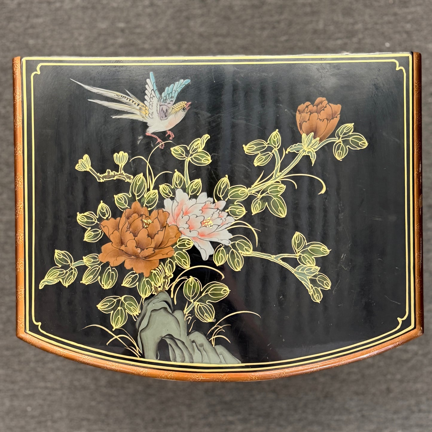 Decorative panel with floral design and bird on a black background
