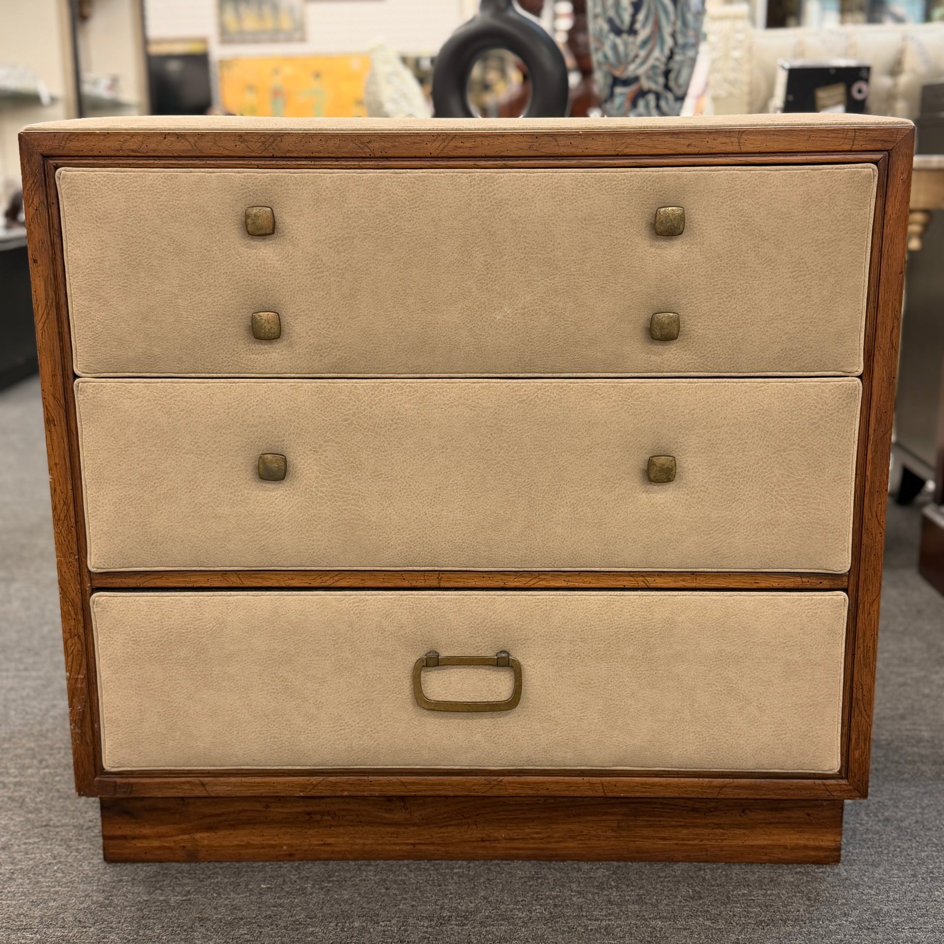 Wooden dresser with beige fabric drawers in a store setting