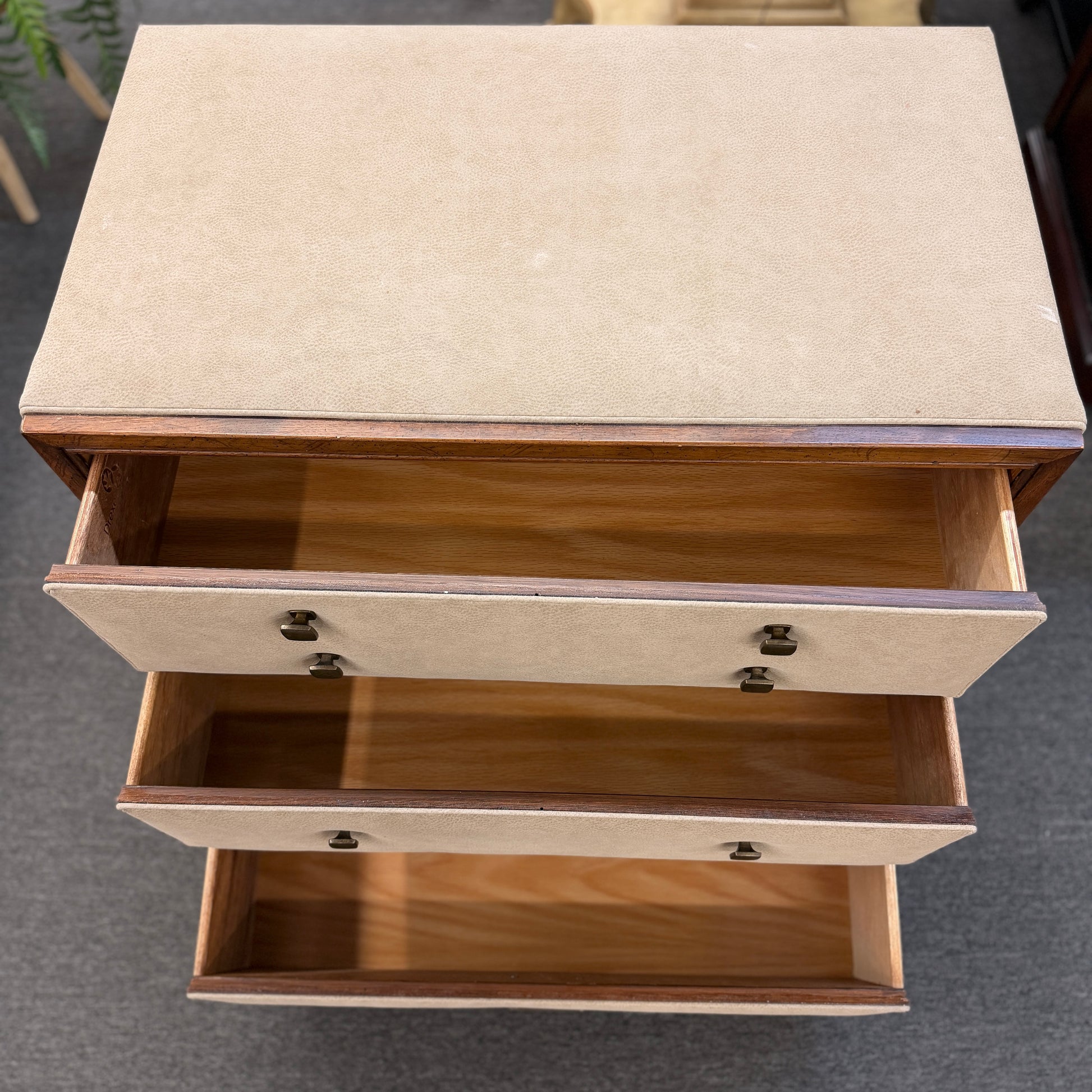 Wooden side table with two drawers on a gray floor.
