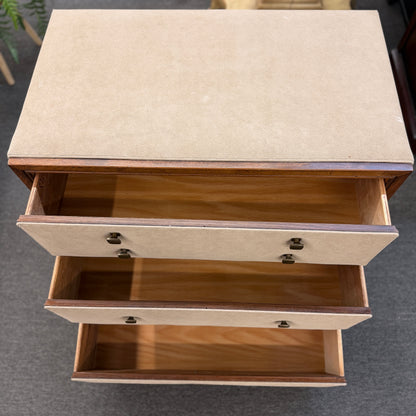Wooden side table with two drawers on a gray floor.